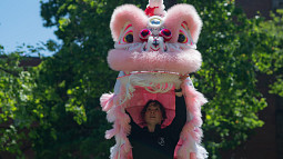 person peeking out from under lion dancing costume